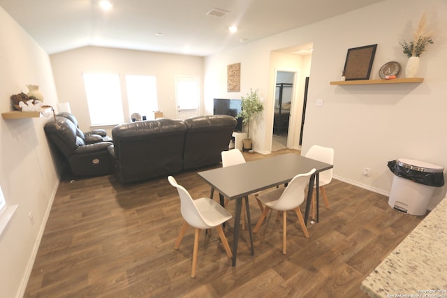 dining room featuring dark wood-type flooring and lofted ceiling