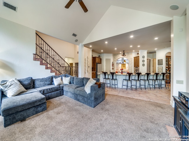 carpeted living room featuring high vaulted ceiling and ceiling fan