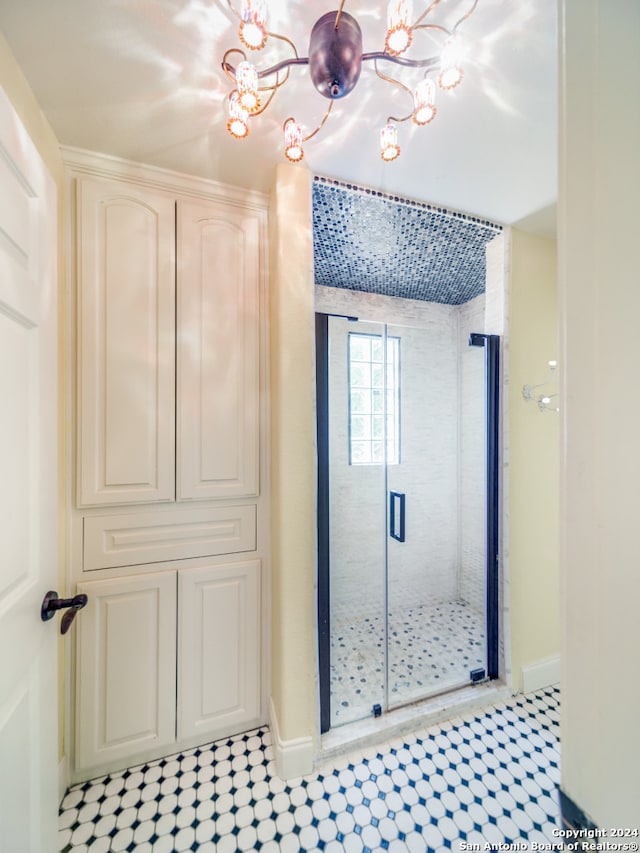 bathroom featuring walk in shower, an inviting chandelier, and tile flooring