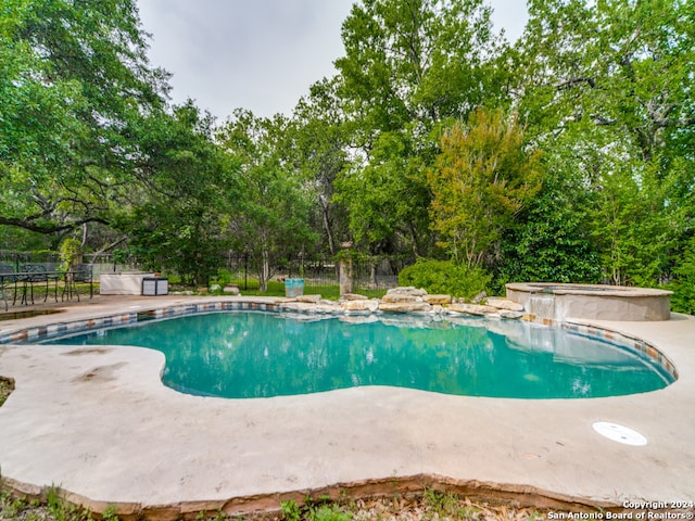 view of swimming pool with an in ground hot tub