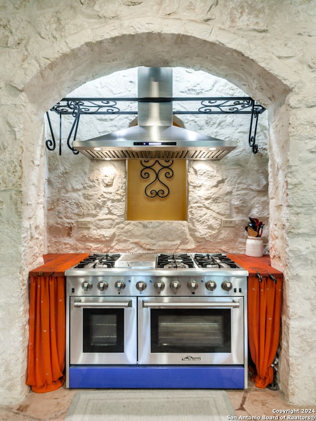 kitchen with exhaust hood and double oven range