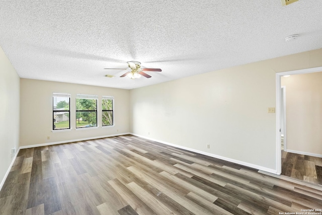 unfurnished room with ceiling fan, dark hardwood / wood-style flooring, and a textured ceiling