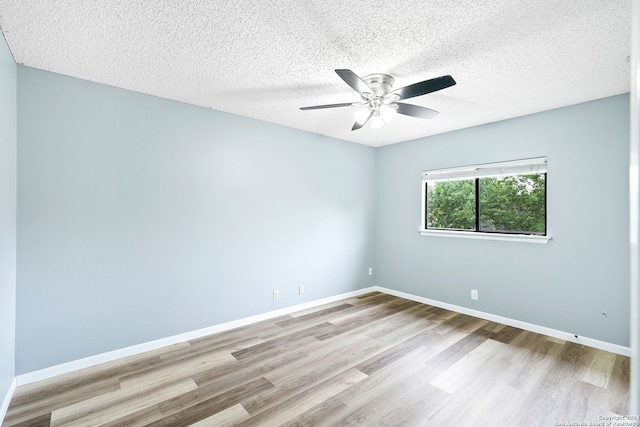 empty room featuring light hardwood / wood-style floors, ceiling fan, and a textured ceiling