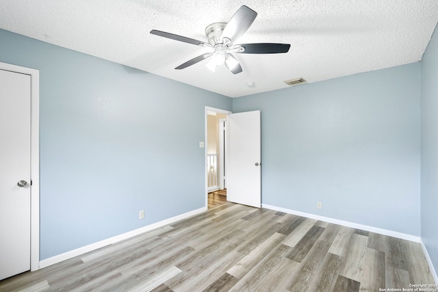 unfurnished room featuring light hardwood / wood-style flooring, ceiling fan, and a textured ceiling