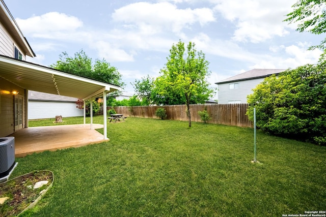 view of yard with central AC and a patio