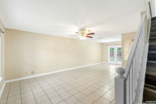 tiled spare room featuring french doors, ceiling fan, and a textured ceiling