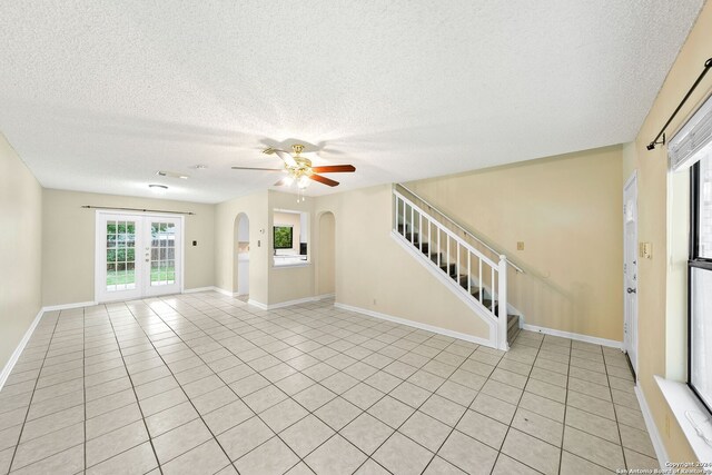 unfurnished room with a textured ceiling, french doors, ceiling fan, and light tile floors