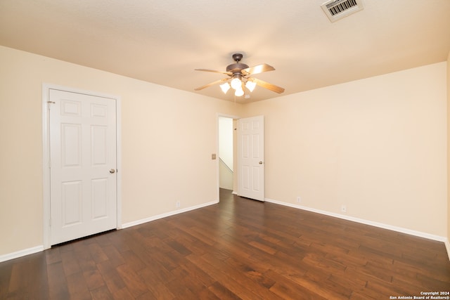 spare room featuring ceiling fan and dark wood-type flooring