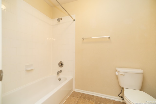 bathroom with tiled shower / bath combo, toilet, and tile flooring