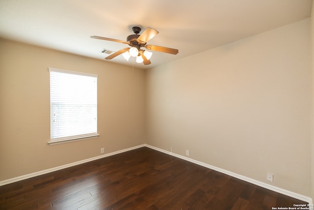 spare room featuring ceiling fan and dark wood-type flooring