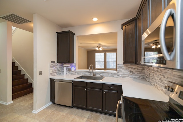 kitchen with appliances with stainless steel finishes, ceiling fan, sink, tasteful backsplash, and dark brown cabinets