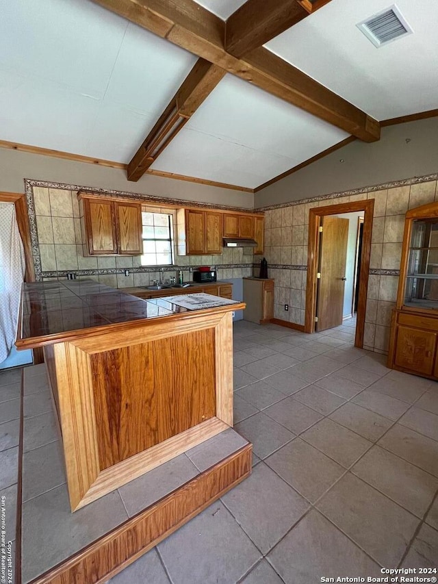 kitchen with tile counters, tile walls, and light tile floors