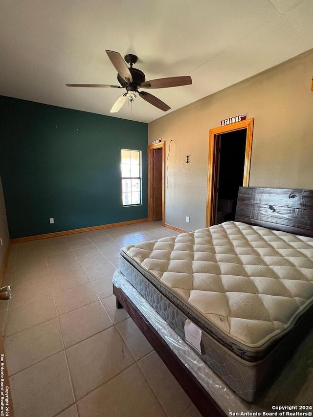 unfurnished bedroom with ceiling fan and light tile floors