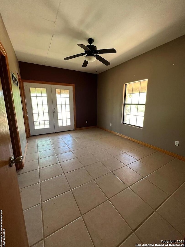 tiled empty room with ceiling fan and french doors