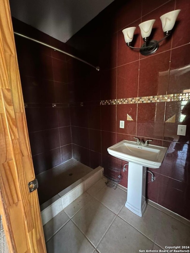 bathroom featuring backsplash, tile flooring, tile walls, and a tile shower