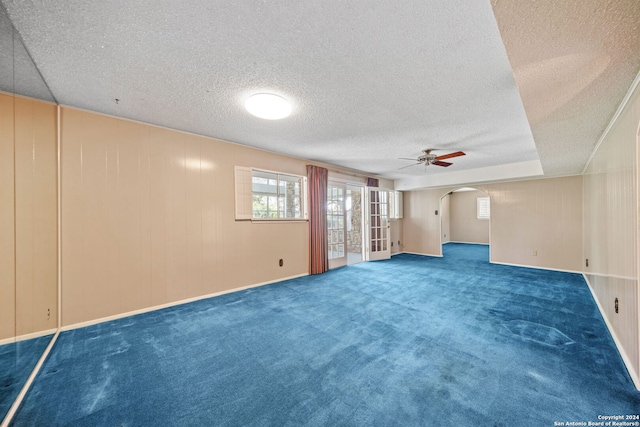 empty room with ceiling fan, a textured ceiling, and carpet