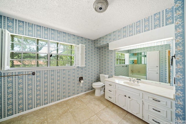 bathroom with tile patterned floors, vanity, a textured ceiling, and toilet