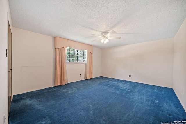 carpeted spare room featuring ceiling fan and a textured ceiling