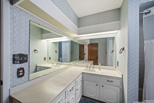 bathroom featuring dual vanity and a textured ceiling