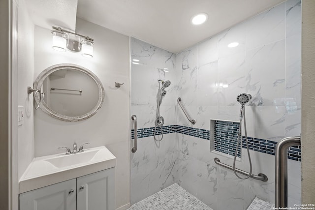 bathroom featuring tiled shower and vanity