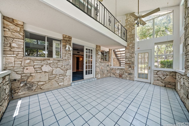 unfurnished sunroom featuring ceiling fan