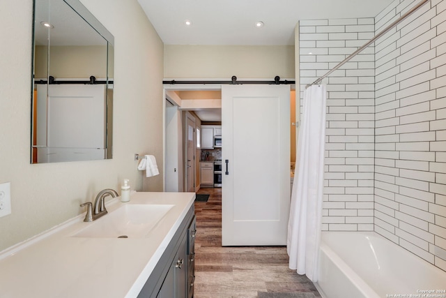 bathroom featuring shower / bathtub combination with curtain, vanity, and hardwood / wood-style floors