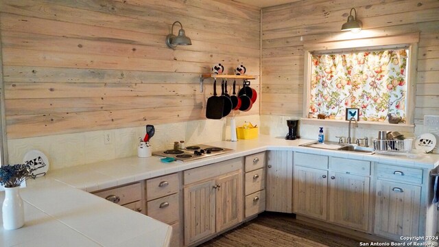 kitchen featuring sink, wooden walls, white electric cooktop, dark hardwood / wood-style floors, and tile counters