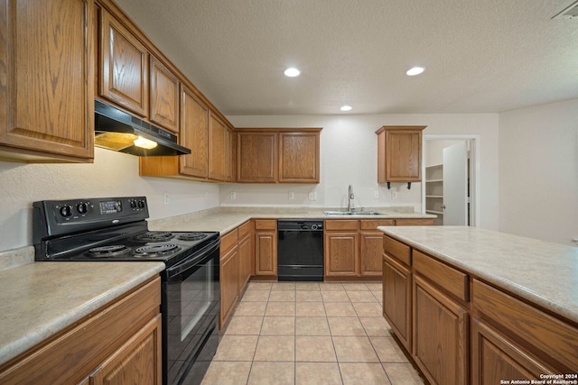 kitchen featuring sink, light tile floors, black appliances, and a textured ceiling