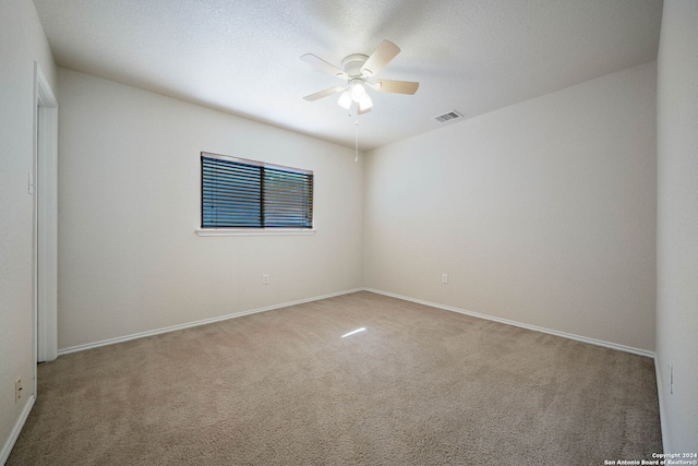 carpeted spare room featuring ceiling fan