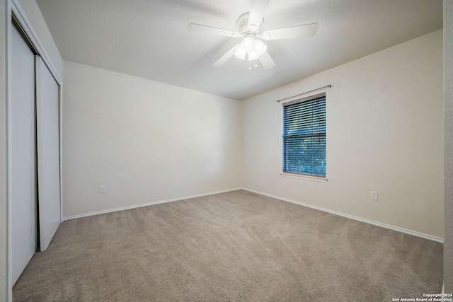 unfurnished bedroom featuring a closet, light carpet, and ceiling fan