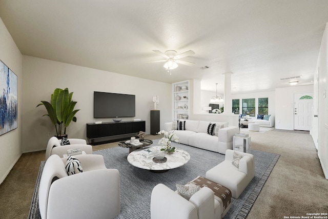 carpeted living room with ceiling fan with notable chandelier and built in features