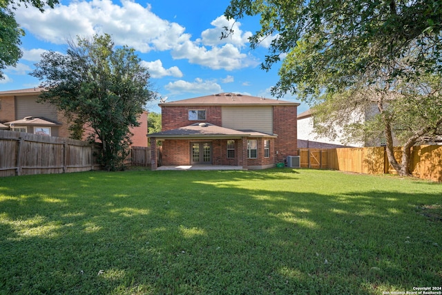 rear view of house with central AC, a yard, and a patio