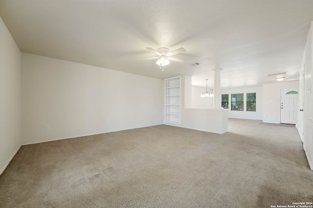 unfurnished living room with light colored carpet, built in features, and ceiling fan with notable chandelier