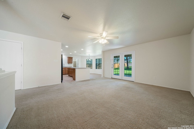 unfurnished living room with ceiling fan and light carpet