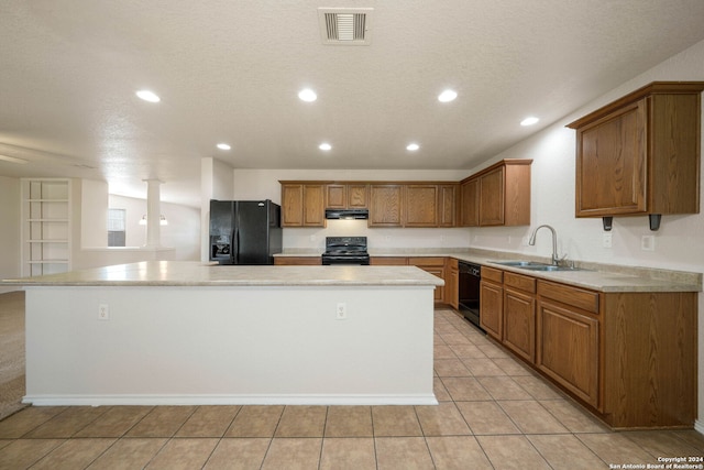 kitchen with sink, light tile floors, a kitchen island, and black appliances