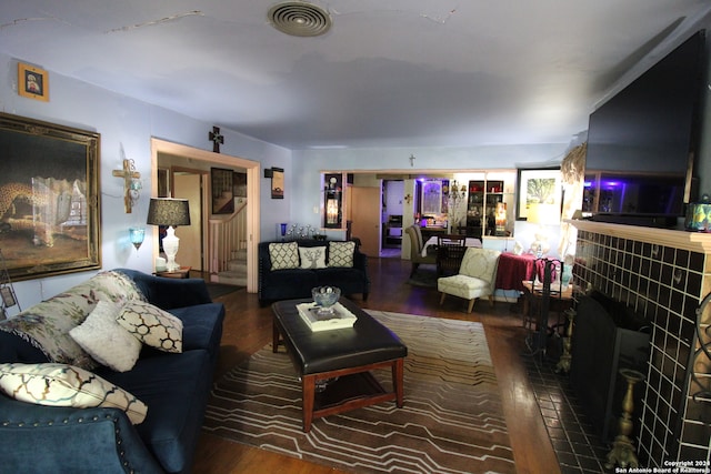 living room with dark wood-type flooring and a fireplace