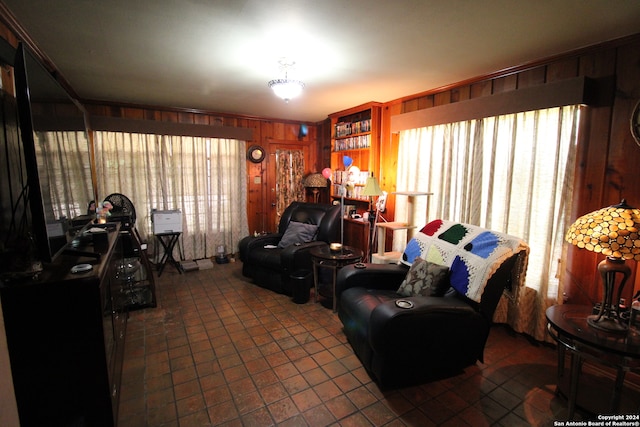 living room featuring dark tile flooring and wooden walls