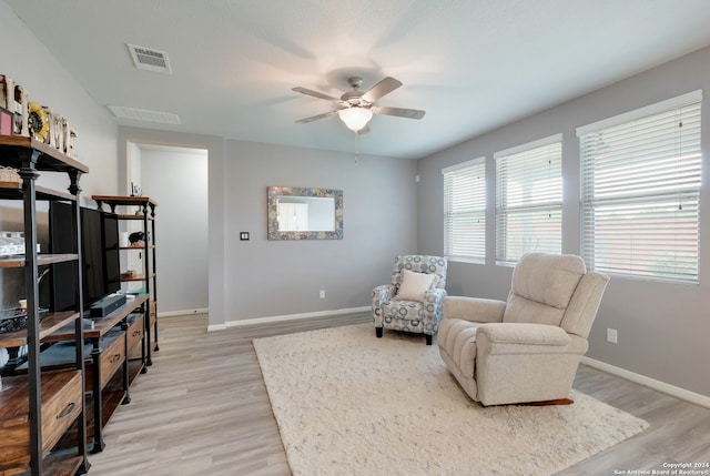 sitting room with ceiling fan and light wood-type flooring