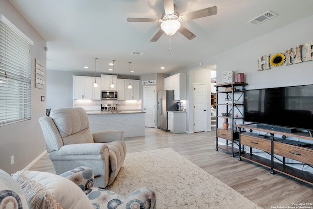 living room featuring ceiling fan and light wood-type flooring