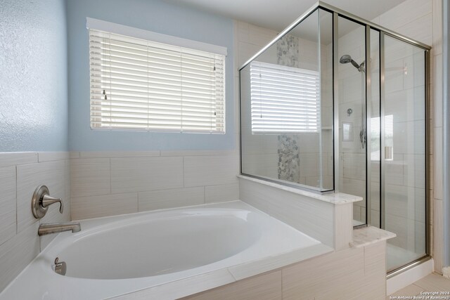 bathroom featuring a healthy amount of sunlight and plus walk in shower