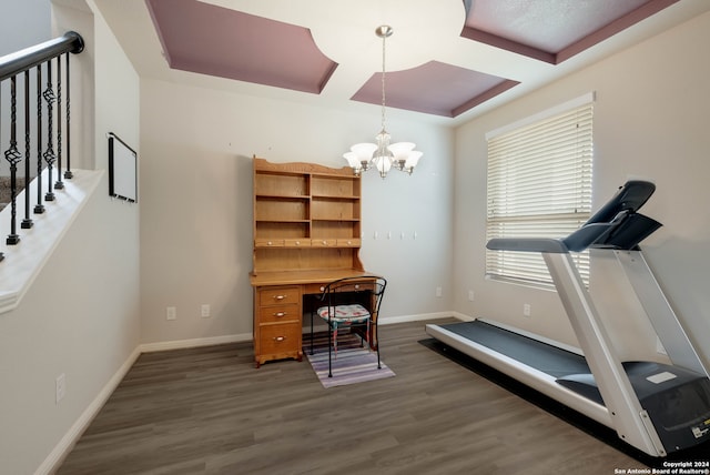 exercise area with dark hardwood / wood-style flooring and a notable chandelier