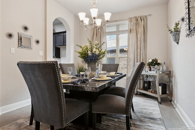 tiled dining room featuring a chandelier