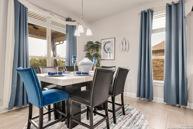 tiled dining area with a chandelier