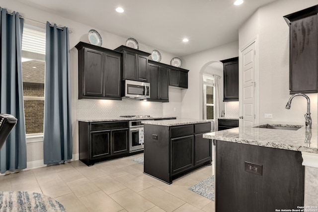 kitchen featuring sink, backsplash, stainless steel appliances, and a wealth of natural light