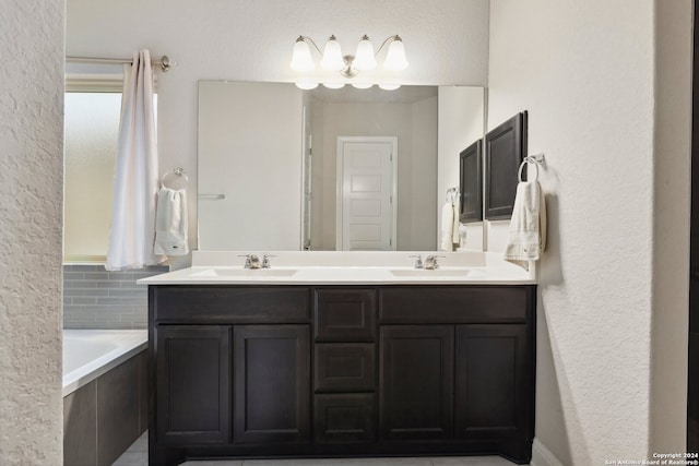 bathroom featuring tile flooring, tiled tub, and dual bowl vanity