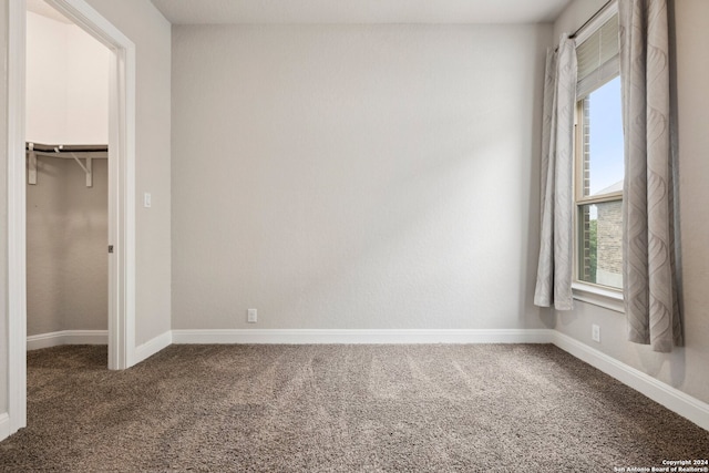 unfurnished bedroom with a closet and dark carpet