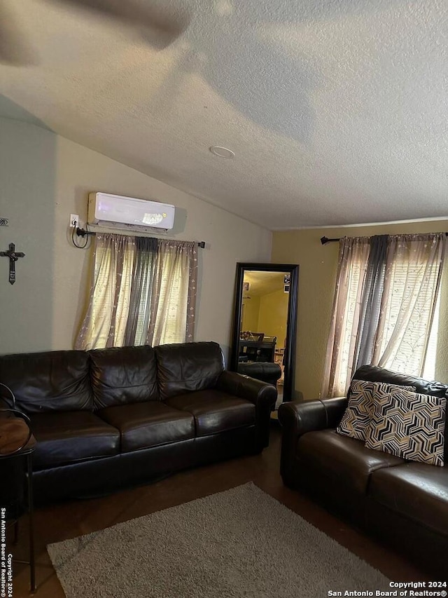 living room with a textured ceiling, a wall mounted AC, and vaulted ceiling