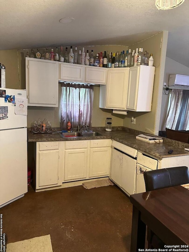 kitchen featuring white appliances, lofted ceiling, a textured ceiling, white cabinets, and sink