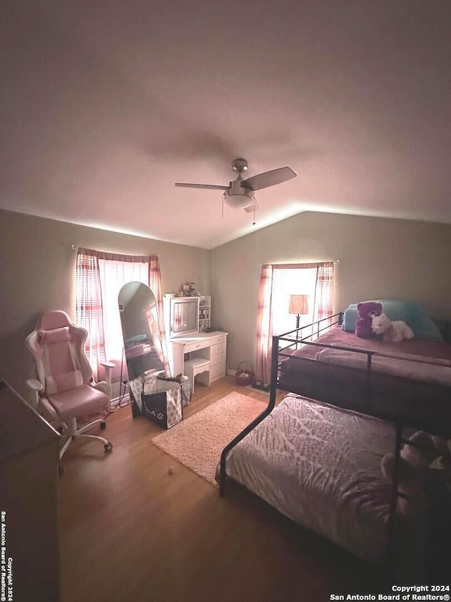 bedroom with ceiling fan, hardwood / wood-style floors, and lofted ceiling