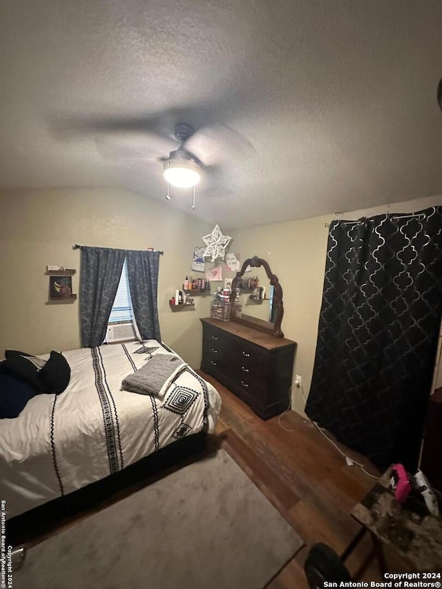 bedroom with a textured ceiling, ceiling fan, and lofted ceiling